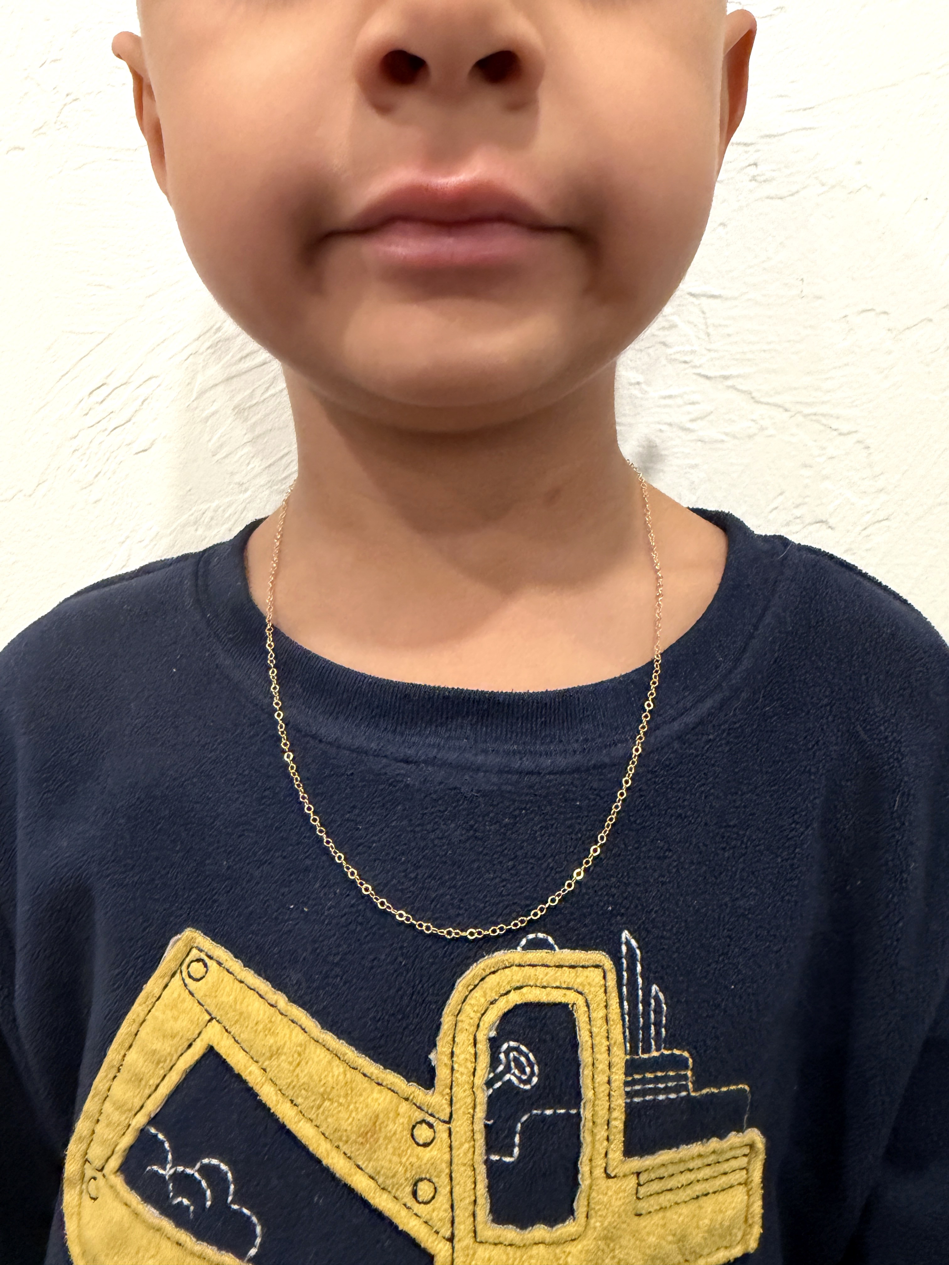 Gold necklace worn by a young client — actual permanent jewelry work